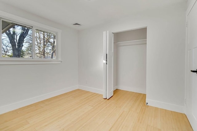 unfurnished bedroom featuring light hardwood / wood-style flooring and a closet