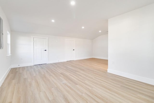 empty room featuring light hardwood / wood-style flooring and vaulted ceiling