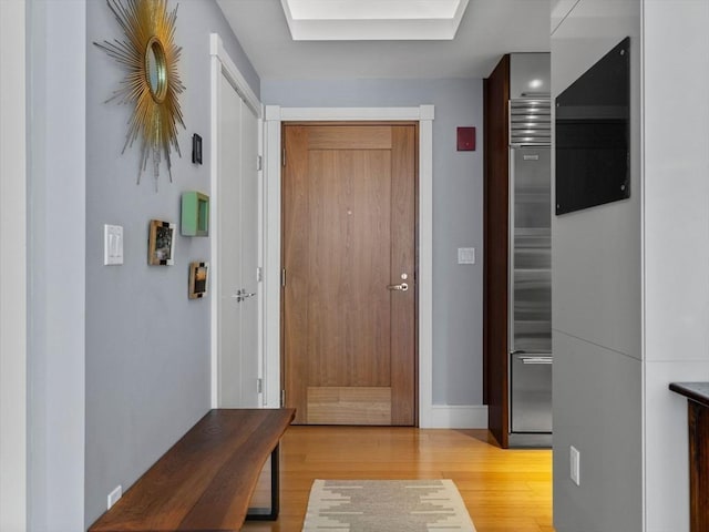 entryway featuring baseboards, light wood-style floors, and a skylight