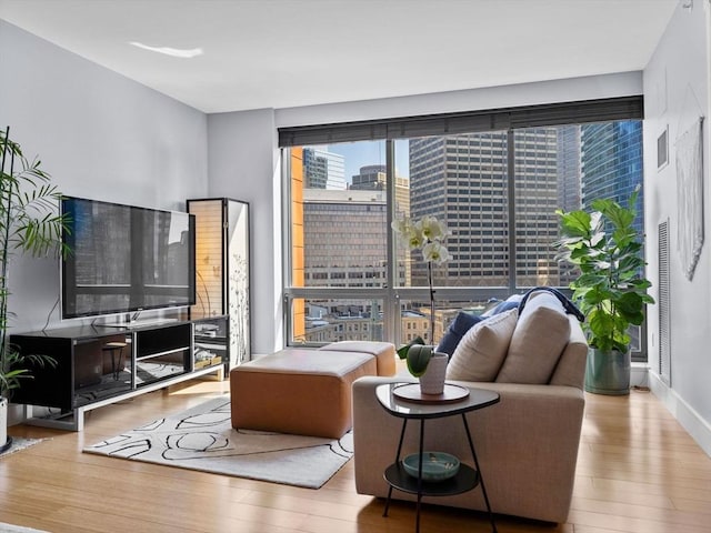 living area featuring visible vents and wood finished floors