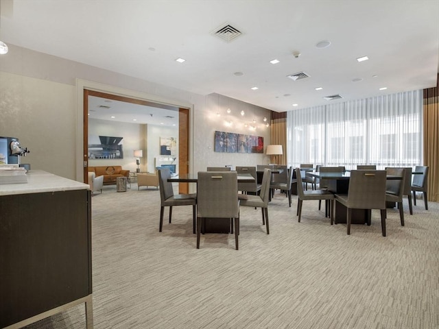 dining room with visible vents and light colored carpet