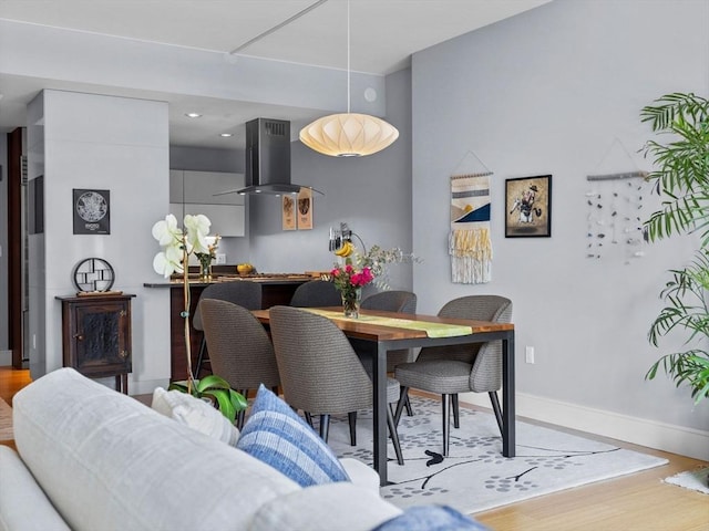 dining room with recessed lighting, baseboards, and wood finished floors