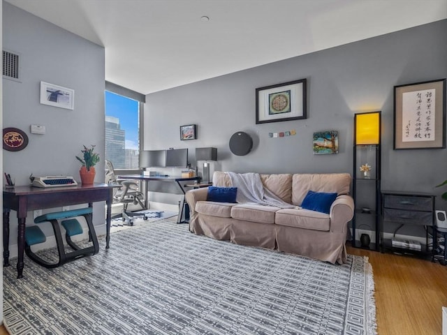 living area with visible vents, wood finished floors, and floor to ceiling windows