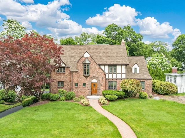 44 Meadowbrook Rd, Longmeadow, MA 01106 - tudor-style house with a front lawn, a chimney, brick siding, and roof with shingles