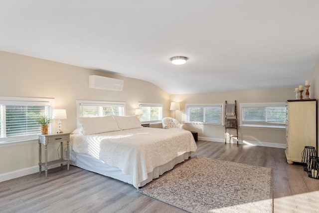 558 Amesbury Rd, Haverhill, MA 01830 - bedroom with a wall mounted AC, wood finished floors, and vaulted ceiling