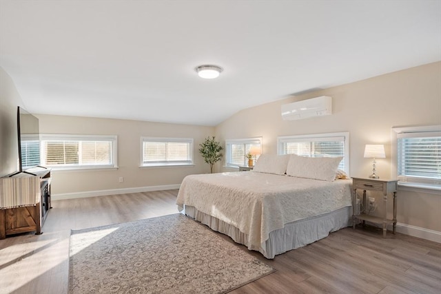 558 Amesbury Rd, Haverhill, MA 01830 - bedroom with an AC wall unit, wood finished floors, and lofted ceiling