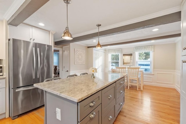 558 Amesbury Rd, Haverhill, MA 01830 - kitchen with freestanding refrigerator, a decorative wall, light wood-style flooring, a kitchen island, and light stone countertops