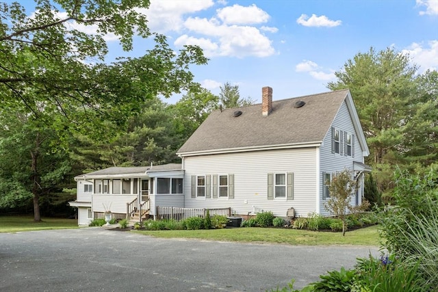 558 Amesbury Rd, Haverhill, MA 01830 - rear view of property with a sunroom, a chimney, roof with shingles, and a yard