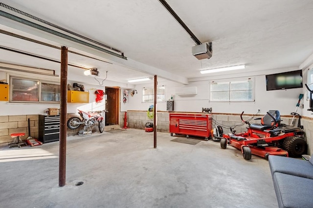 558 Amesbury Rd, Haverhill, MA 01830 - garage with a garage door opener, a wall unit AC, and a workshop area