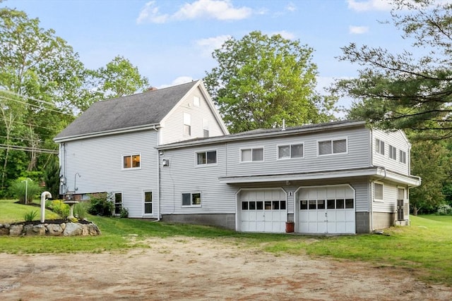 558 Amesbury Rd, Haverhill, MA 01830 - back of property featuring dirt driveway, an attached garage, and a yard