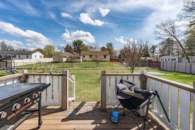wooden deck with a residential view, a lawn, and a fenced backyard