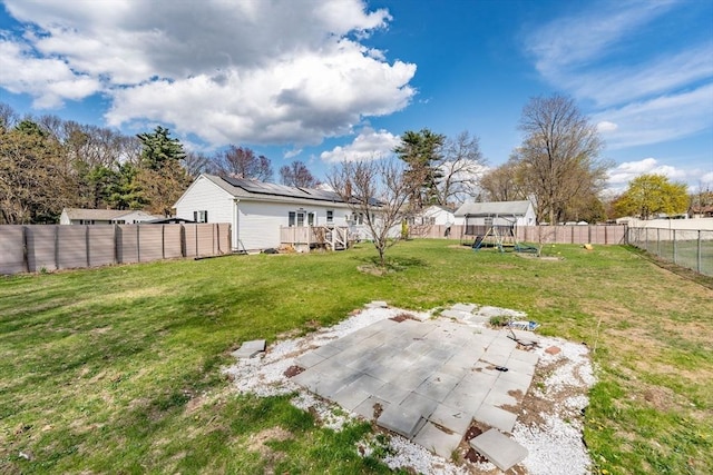 view of yard featuring a patio, a fenced backyard, a playground, and a deck