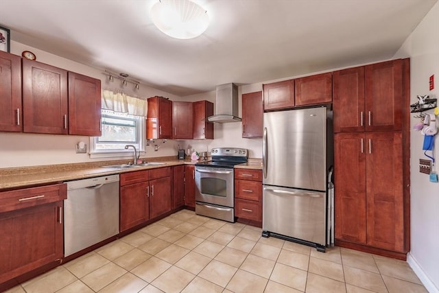 kitchen featuring light countertops, wall chimney range hood, light tile patterned floors, a sink, and appliances with stainless steel finishes