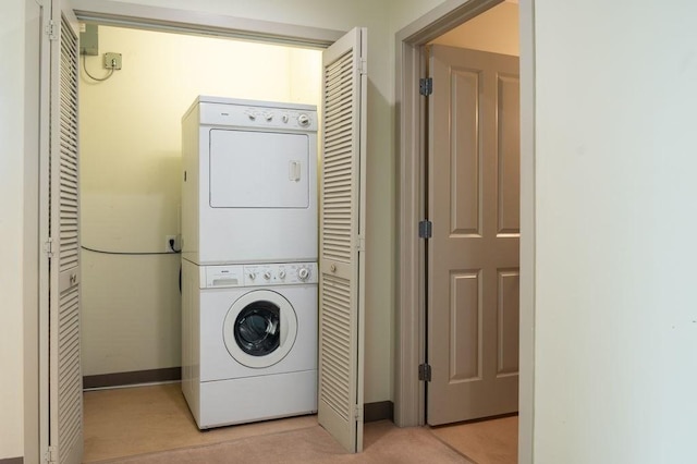 clothes washing area featuring stacked washer / dryer