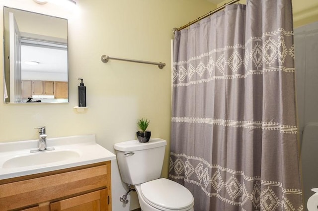 bathroom with curtained shower, vanity, and toilet