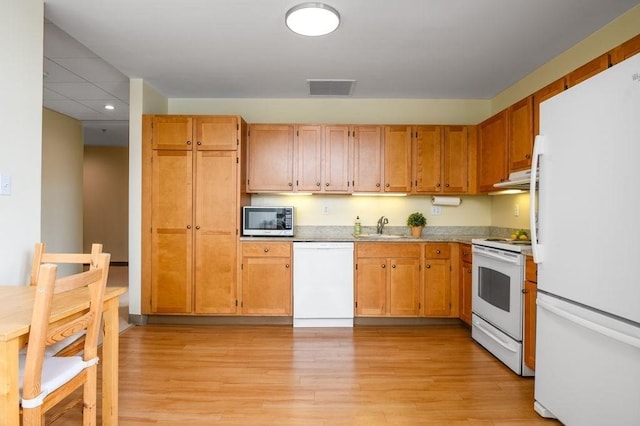 kitchen featuring light wood-type flooring, white appliances, and sink