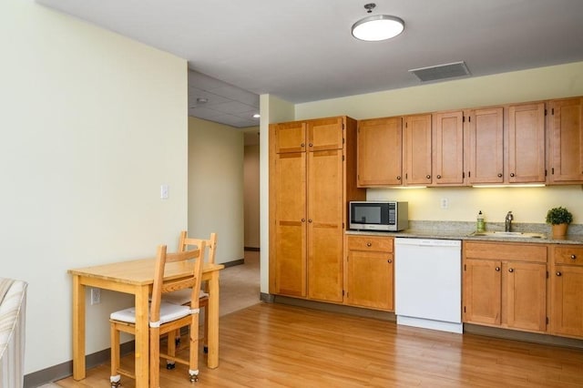 kitchen featuring light hardwood / wood-style floors, dishwasher, and sink