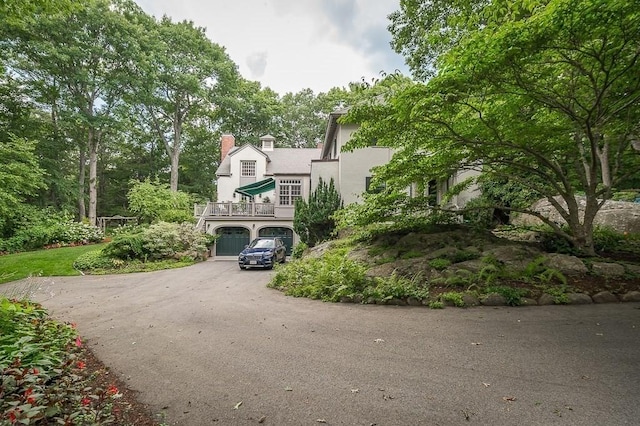 4 Dexter Ln, Manchester, MA 01944 - view of front facade featuring an attached garage, stucco siding, asphalt driveway, and a chimney