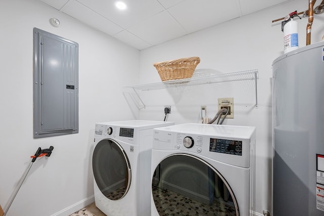 clothes washing area with electric panel, electric water heater, and washing machine and dryer