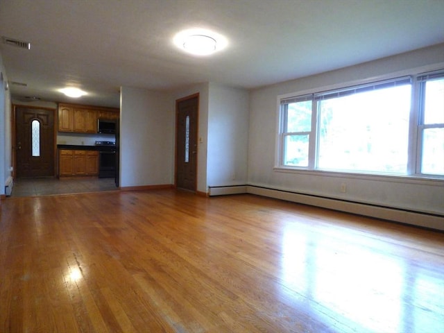 25 Williams St, Ludlow, MA 01056 - unfurnished living room featuring light wood finished floors, baseboards, and a baseboard heating unit