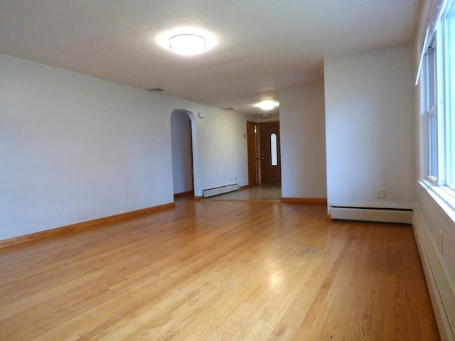25 Williams St, Ludlow, MA 01056 - unfurnished room with a baseboard heating unit, arched walkways, wood finished floors, and baseboards