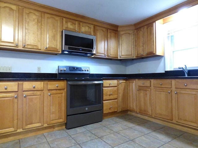 25 Williams St, Ludlow, MA 01056 - kitchen featuring stainless steel appliances, brown cabinets, light tile patterned floors, and a sink