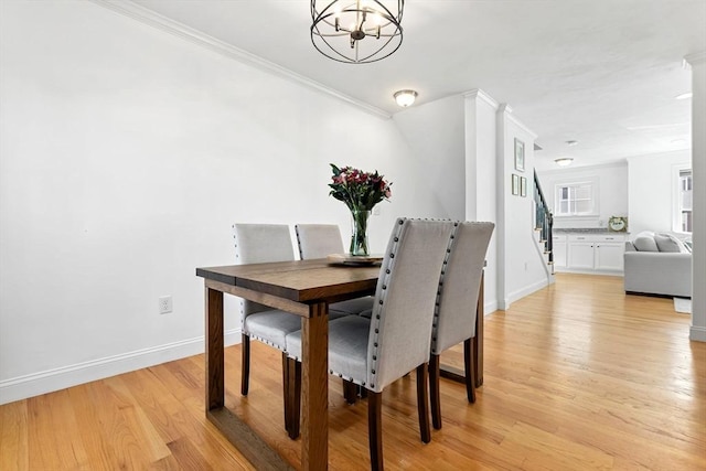 dining space featuring a notable chandelier, crown molding, and light hardwood / wood-style floors