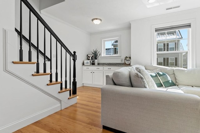 living room featuring ornamental molding and light hardwood / wood-style floors