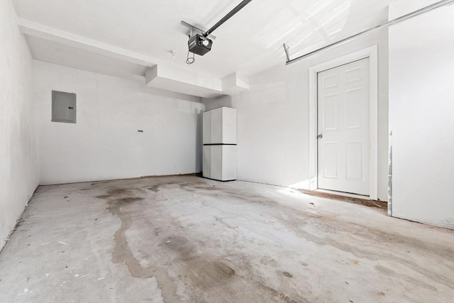 garage featuring a garage door opener, electric panel, and white refrigerator