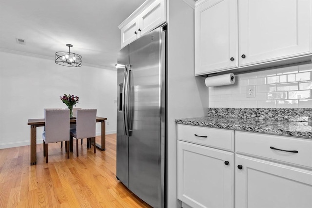 kitchen with light hardwood / wood-style flooring, white cabinetry, crown molding, stainless steel fridge, and tasteful backsplash