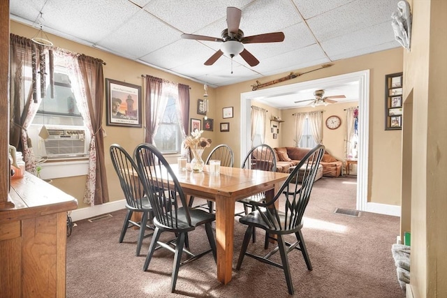 carpeted dining space featuring cooling unit and a drop ceiling