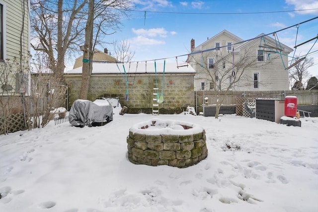 snowy yard with an outdoor fire pit