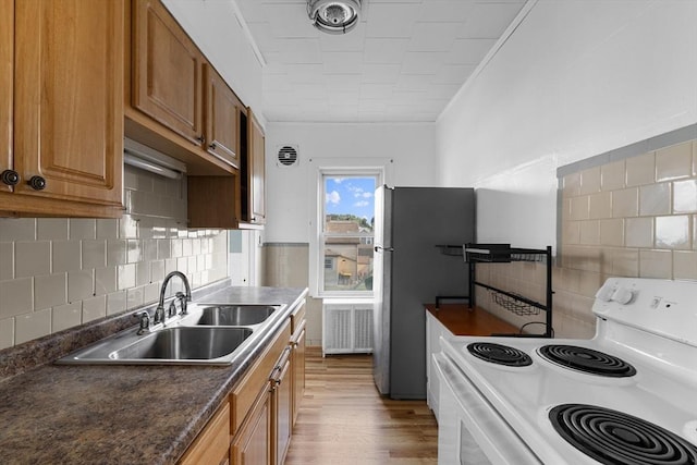 27 Cook St, Fall River, MA 02724 - kitchen featuring white electric stove, light wood-style floors, brown cabinets, and decorative backsplash