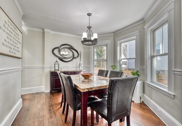 dining space with a chandelier, dark wood-style floors, crown molding, and baseboards