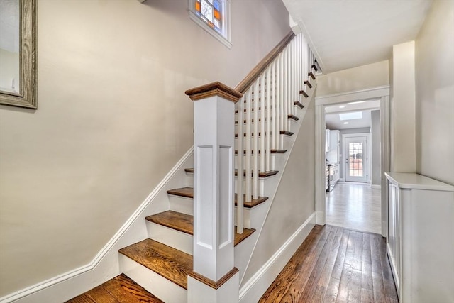 stairway with wood-type flooring and baseboards