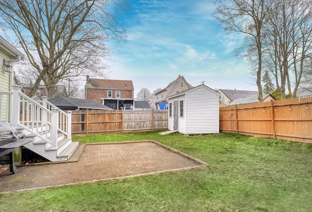 view of yard with an outbuilding, a shed, and a patio area