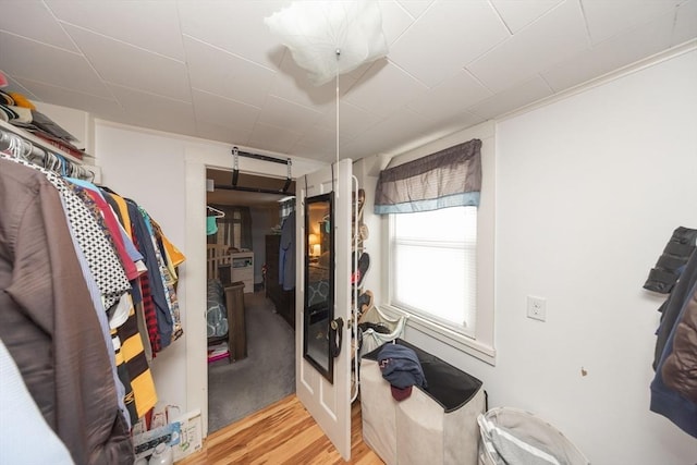 walk in closet with light hardwood / wood-style floors