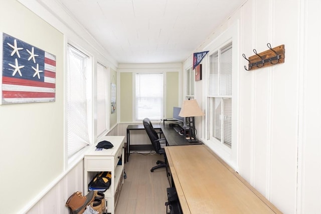 office area with light wood-type flooring and ornamental molding