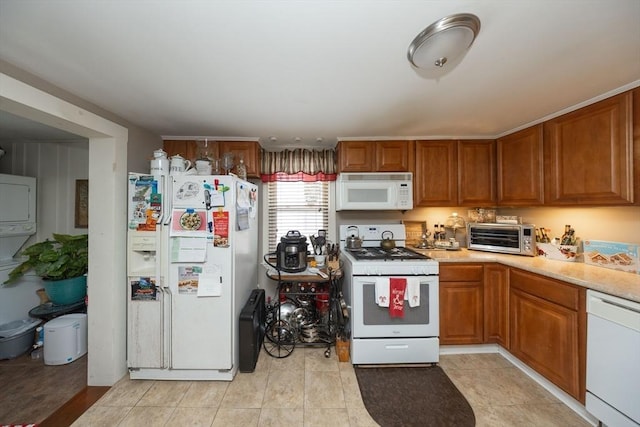 kitchen featuring white appliances and stacked washer / dryer