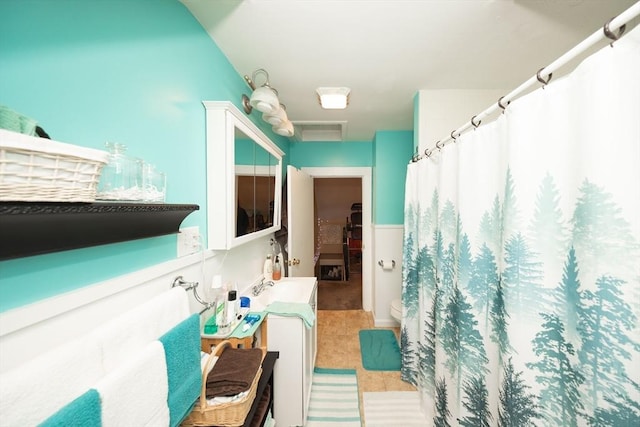 bathroom featuring tile patterned flooring, vanity, toilet, and walk in shower