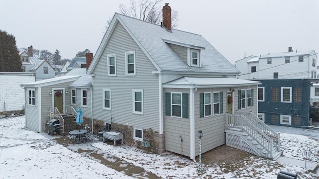 view of snow covered rear of property