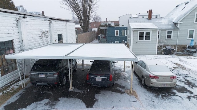 yard covered in snow with a carport