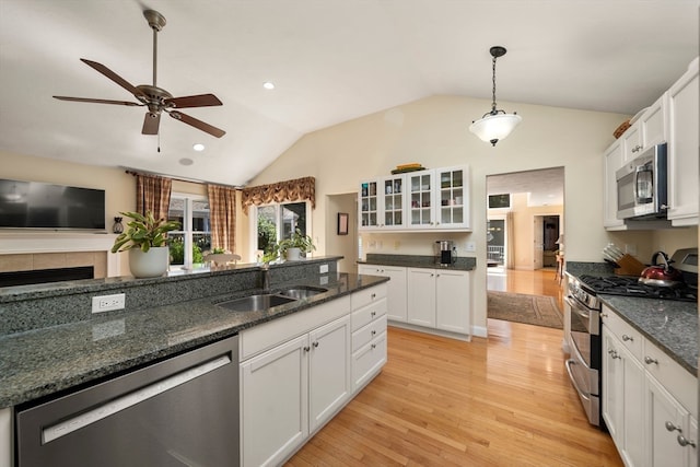 kitchen featuring white cabinets, stainless steel appliances, and vaulted ceiling