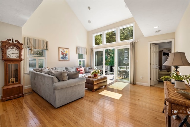 living room featuring high vaulted ceiling and light wood-type flooring