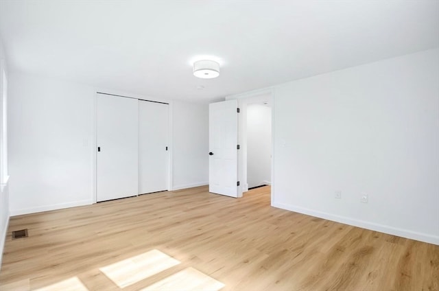 unfurnished bedroom featuring a closet and light hardwood / wood-style floors