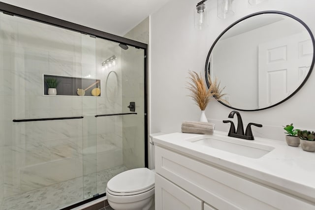 bathroom featuring vanity, toilet, and a shower with door