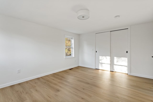 unfurnished bedroom featuring light hardwood / wood-style floors and a closet