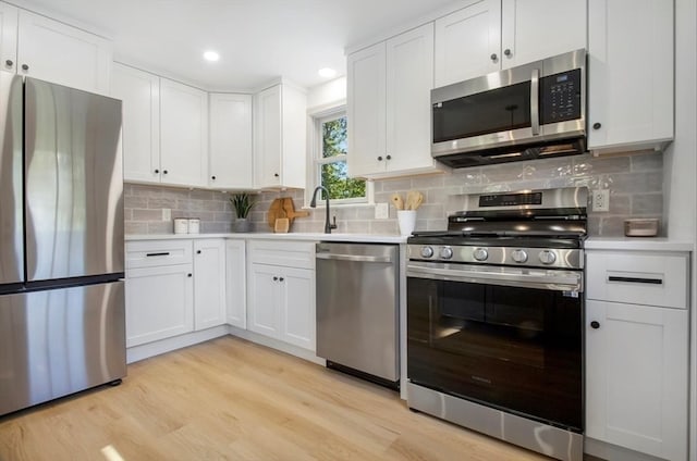 kitchen featuring white cabinets, appliances with stainless steel finishes, and light wood-type flooring