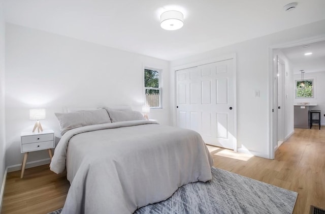 bedroom with light wood-type flooring and a closet