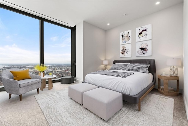 bedroom featuring a wall of windows, light carpet, and multiple windows